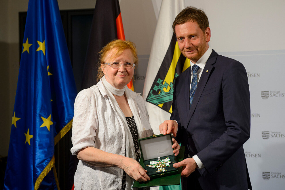 Ein Mann und eine Frau halten eine Medaille in der Hand.