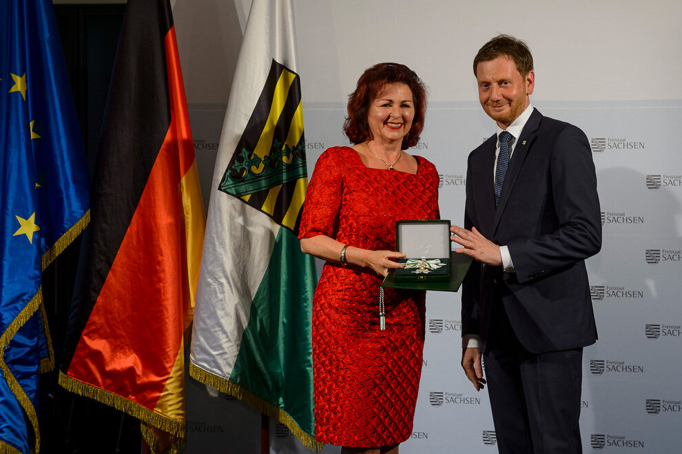 Ein Mann und eine Frau halten eine Medaille in der Hand.