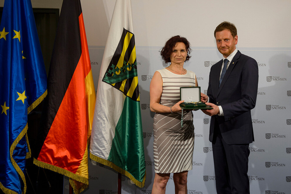 Ein Mann und eine Frau halten eine Medaille in der Hand.