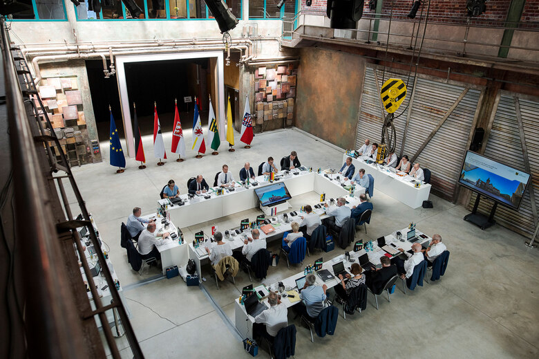 EIn Konferenztisch steht in einem alten, sanierten Industriesaal.